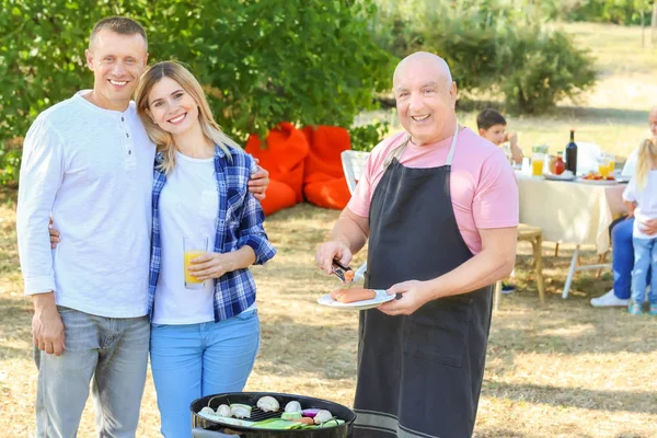 Lykkelig familie som har grillfest utendørs – stockfoto