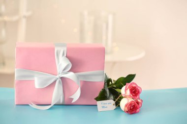 Çiçekli masada anneler günü için hediye kutusu