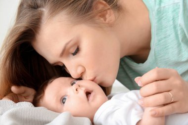 Genç anne ve evde yatakta şirin bebek