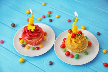 Ahşap arka plan üzerinde renkli lezzetli kekler plakaları