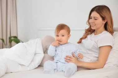 Genç anne ile bebek evde yatakta