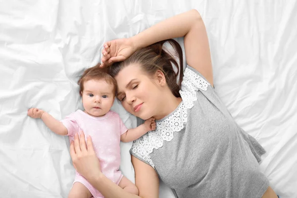 Ibu muda dan bayi lucu di tempat tidur di rumah — Stok Foto