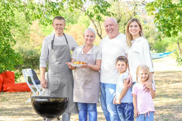 Lykkelig familie som har grillfest utendørs – stockfoto