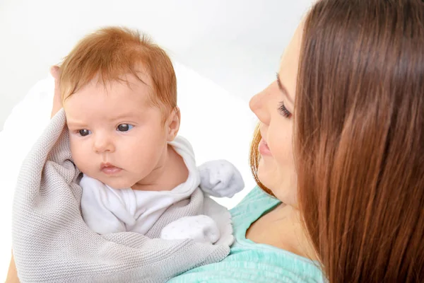 Young mother holding cute little baby indoors — Stock Photo, Image