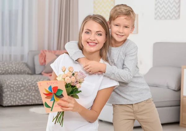 Ung kvinna med hennes lilla son och presenter till mors dag hemma — Stockfoto