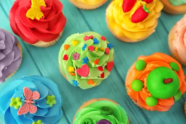 Leckere bunte Cupcakes auf Holz Hintergrund — Stockfoto