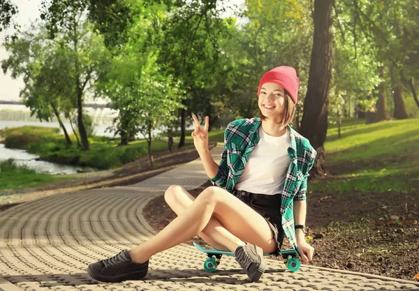 Hipster meisje met skateboard in park — Stockfoto