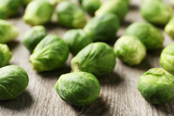 Raw Brussels sprouts on wooden table, closeup — Stock Photo, Image
