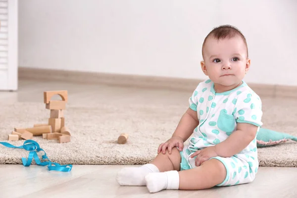 Söt baby sitter på golvet hemma — Stockfoto