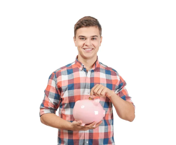 Giovane uomo mettendo moneta in salvadanaio su sfondo bianco — Foto Stock
