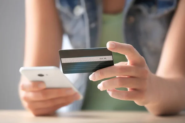 Mujer con tarjeta de crédito y teléfono móvil —  Fotos de Stock