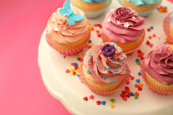 Renk arka plan üzerinde lezzetli parlak kekler tepsi — Stok fotoğraf