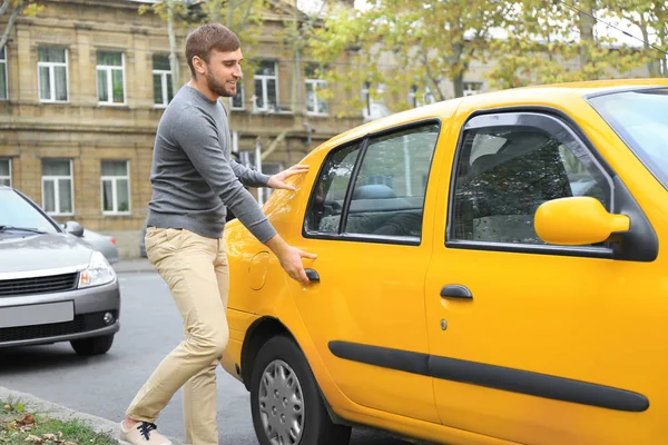 Młody człowiek dostania się do samochodu taxi — Zdjęcie stockowe