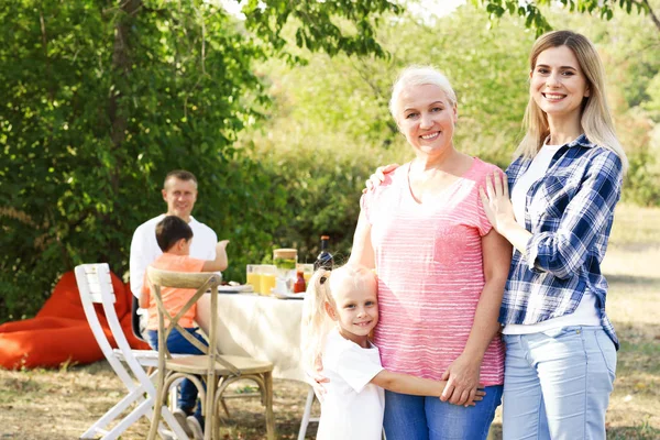 Happy family having barbecue party outdoors — Stock Photo, Image