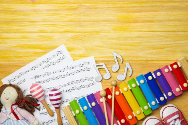 Ahşap arka plan üzerinde müzik yaprakları ile güzel kompozisyon. Bebek şarkıları kavramı