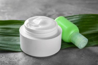 Kavanoz ve şişe gri arka plan üzerinde doğal krem