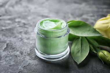 Yeşil gövdeli gri arka plan üzerinde krem Cam Kavanoz