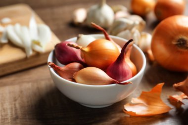 Ahşap masa üzerinde farklı soğanlı kase