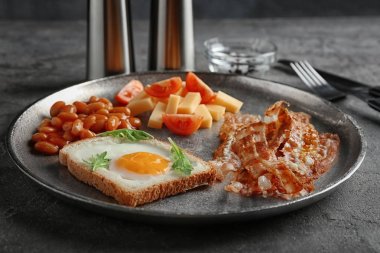 Tabak kızarmış yumurta, pastırma ve tablo fasulye ile