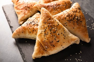 Kayrak plakalı gri arka plan üzerinde lezzetli samosas