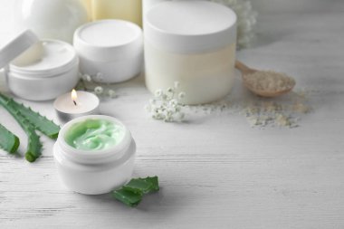 Vücut üzerinde ahşap masa krem kavanoz ile güzel kompozisyon