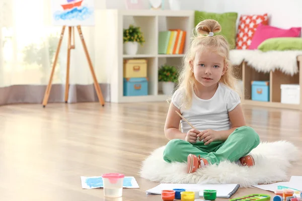 Cute girl painting picture on sheet of paper, indoors — Stock Photo, Image