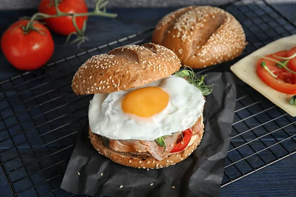 Smaczne burger z szynki i jaj na siatce metalowej — Zdjęcie stockowe