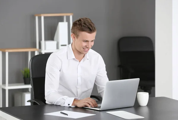 Bell'uomo con computer portatile in ufficio — Foto Stock