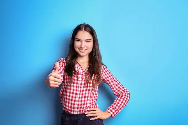 Smuk smilende kvinde viser tommelfinger op gestus på farve baggrund - Stock-foto