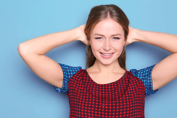 Mooie jonge lachende vrouw op kleur achtergrond — Stockfoto