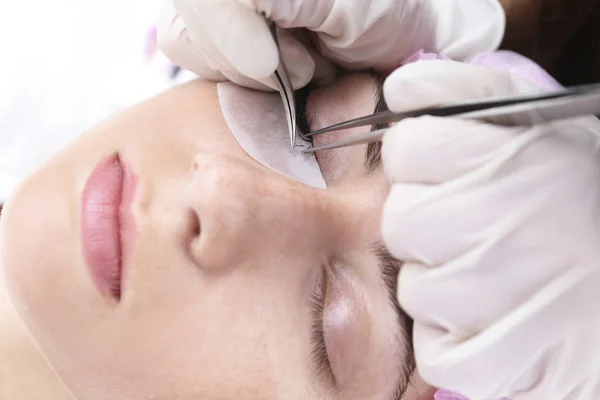 Young woman undergoing eyelash extensions, closeup — Stock Photo, Image