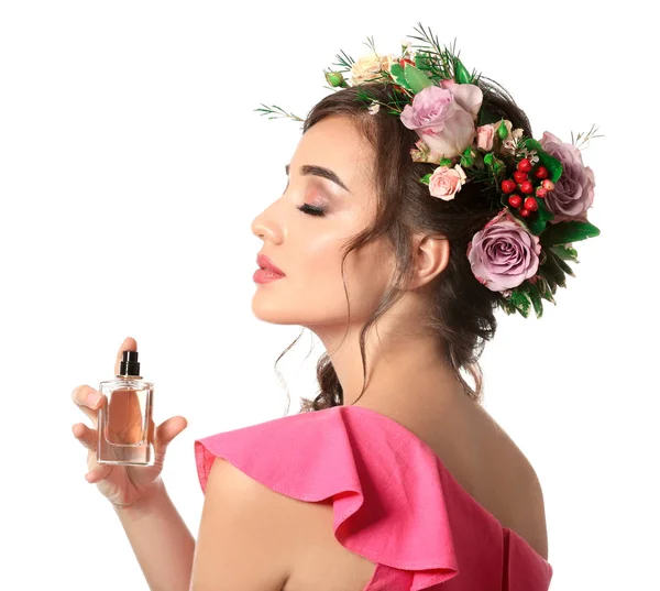 Красивая молодая женщина с бутылкой цветочных духов на белом фоне — стоковое фото