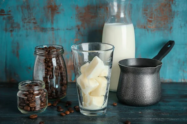 Σύνθεση με παγωμένο γάλα κύβους και κόκκους καφέ στο τραπέζι — Φωτογραφία Αρχείου