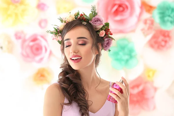 Piękna młoda kobieta z butelki perfum kwiatowy na kolor tła — Zdjęcie stockowe