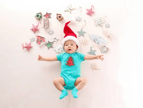 Lindo bebé en el sombrero de Santa y decoraciones de Navidad sobre fondo claro — Foto de Stock