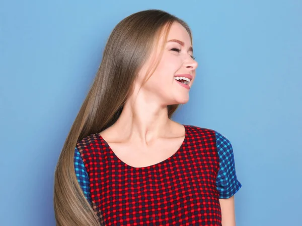 Mooie jonge lachende vrouw op kleur achtergrond — Stockfoto