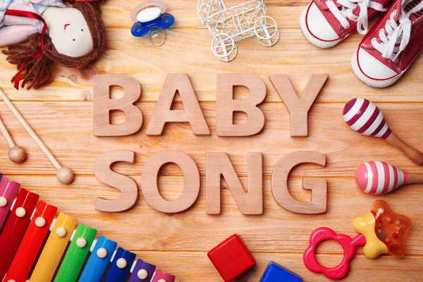 Texto BABY SONG e brinquedos sobre fundo de madeira — Fotografia de Stock
