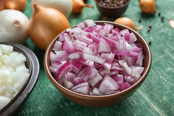 Ahşap masa üzerinde kesilmiş soğan ile kase