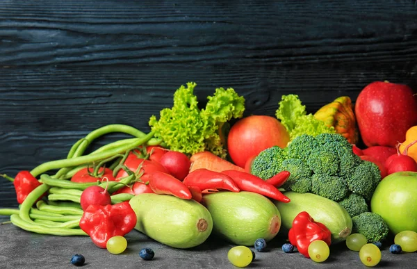 Composição com diferentes frutas e legumes na mesa contra fundo de madeira escura — Fotografia de Stock