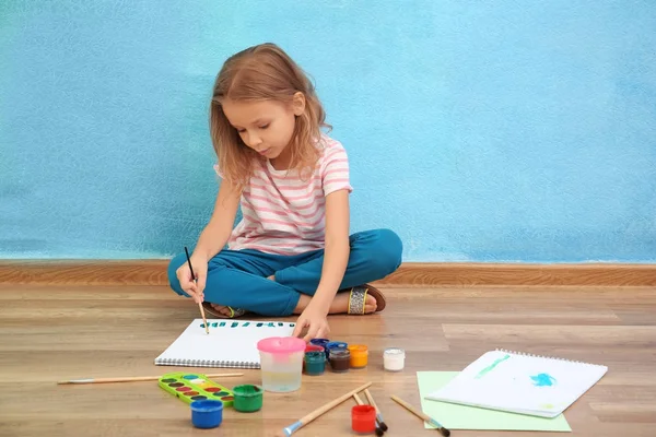 Милая маленькая девочка рисует дома — стоковое фото