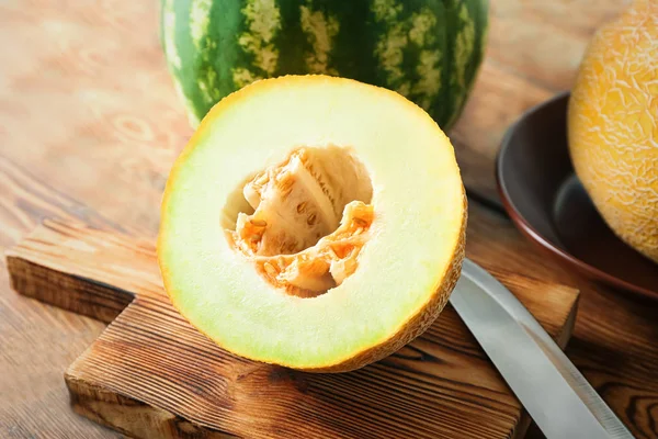 Half of yummy melon on wooden table — Stock Photo, Image
