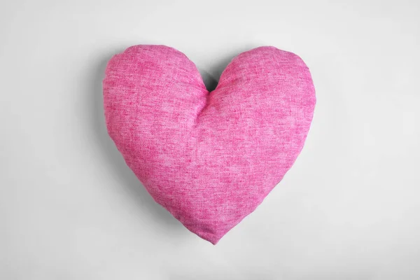 Travesseiro macio em forma de coração no fundo claro — Fotografia de Stock