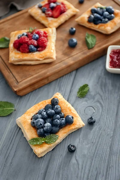 Composition with tasty berry pastries on wooden table