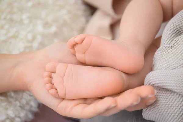 Mother holding baby feet, closeup — Stock Photo, Image