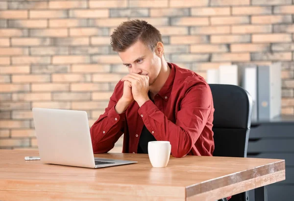 Alvorlig mand med laptop i kontoret - Stock-foto