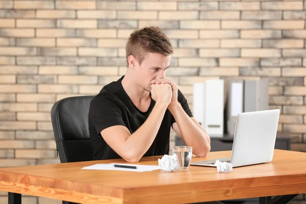 Homem sério com laptop no escritório — Fotografia de Stock