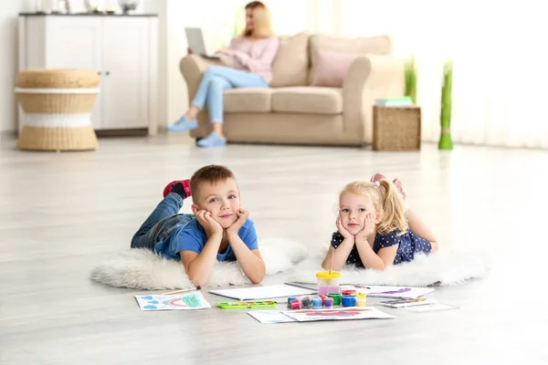 Schattige kinderen schilderij van foto's op vellen papier, binnenshuis — Stockfoto