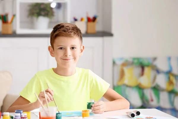 Маленький хлопчик малює за столом — стокове фото