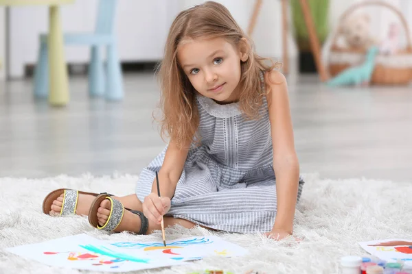 Kleines Mädchen malt, während es zu Hause auf dem Boden sitzt — Stockfoto