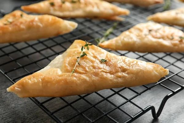 Cooling rack with delicious samosas on table, closeup — Stock Photo, Image